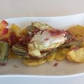 Huevos fritos sobre patatas y alcachofas