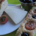 Focaccia de queso, con olivas y tomates cherry.